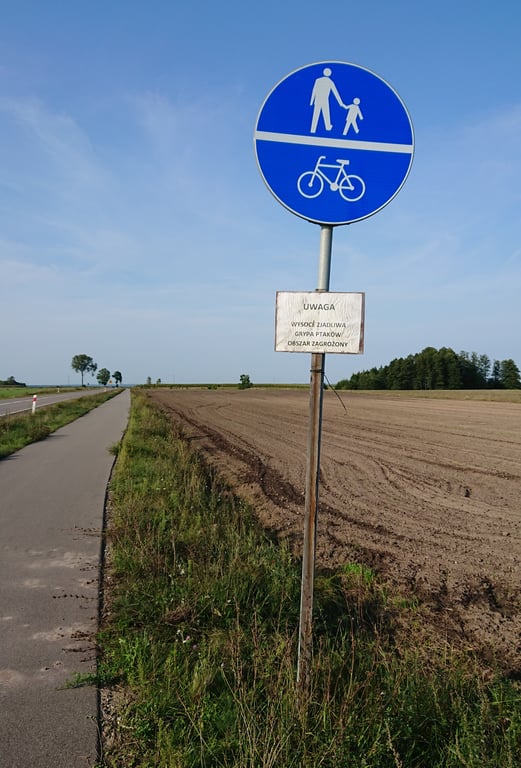 Cartel de advertencia por gripe aviar en zona rural europea