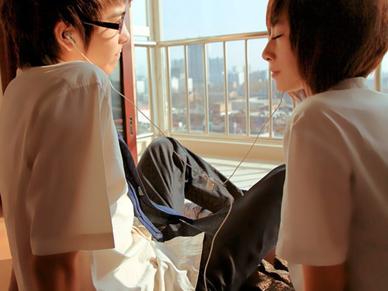 两个人用一副耳机听音乐