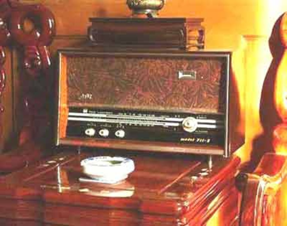 电台带着耳机对着面前的作业放空