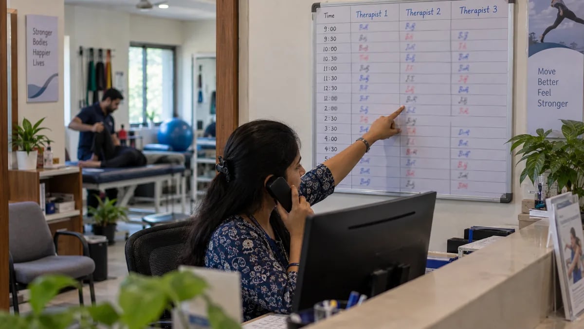 A physiotherapy clinic's whiteboard schedule showing appointment slots across three therapists
