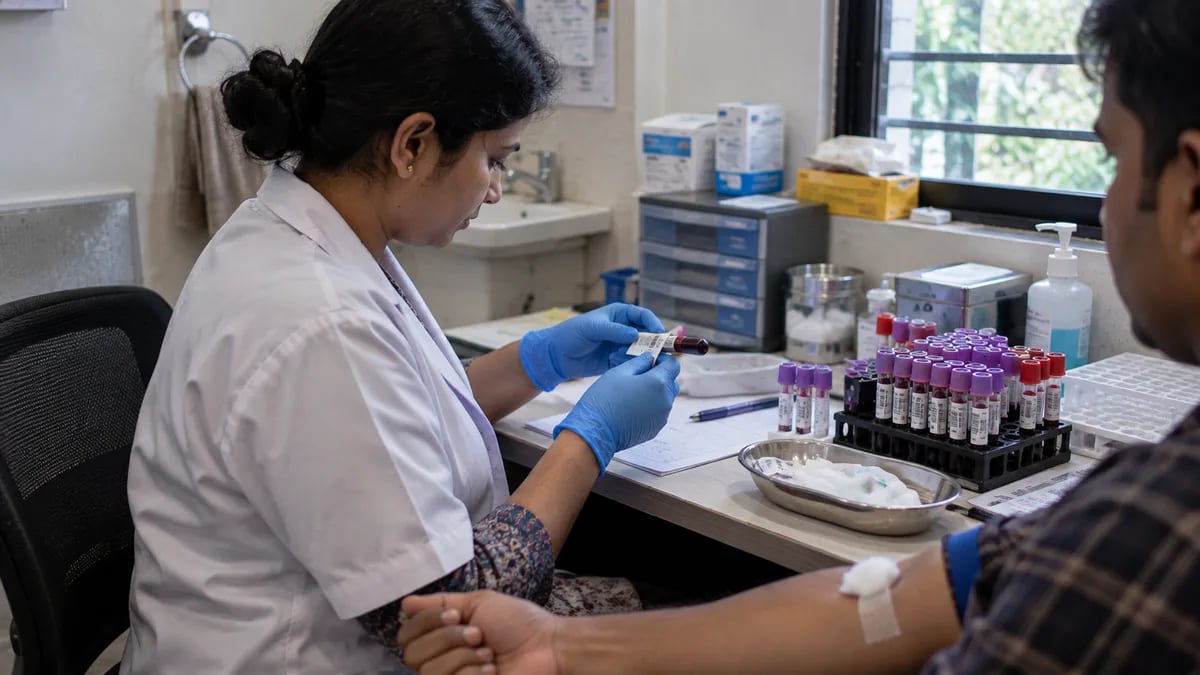 A phlebotomist labelling a blood sample immediately after collection