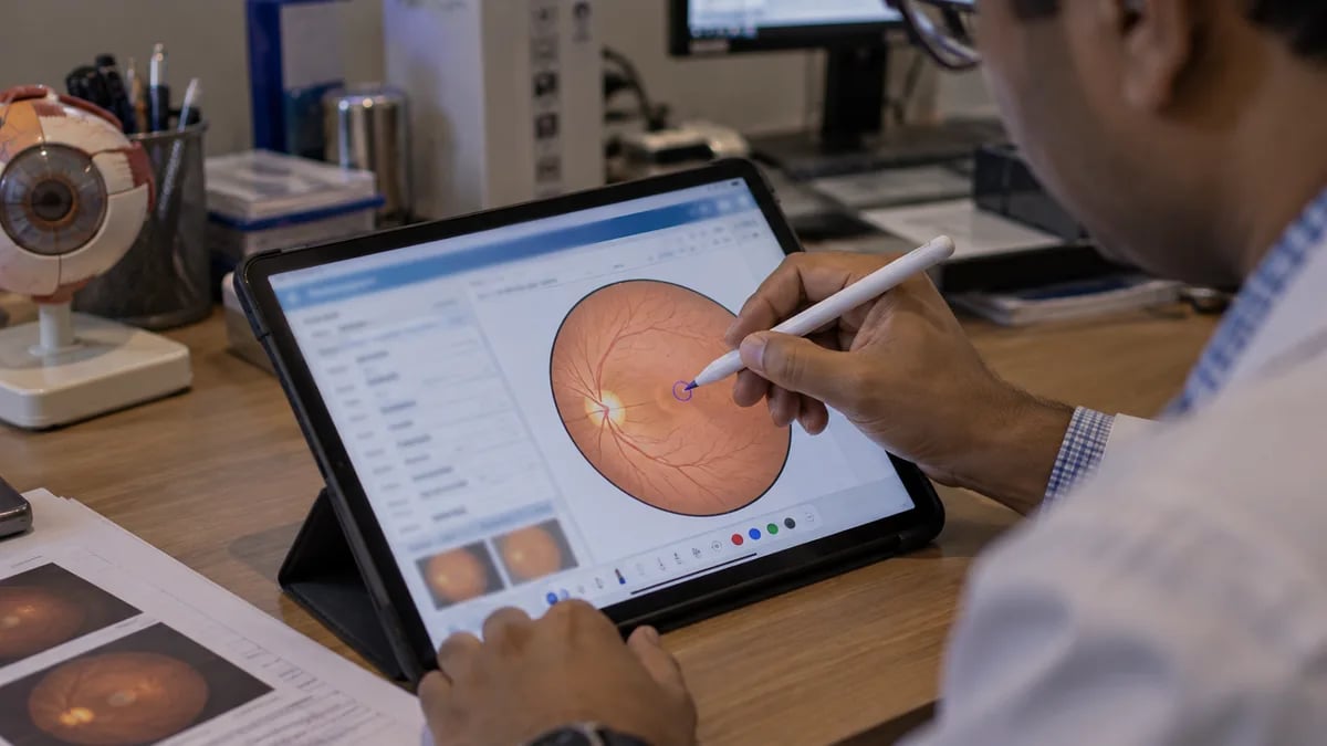 A doctor marking a finding directly onto an eye diagram on a tablet