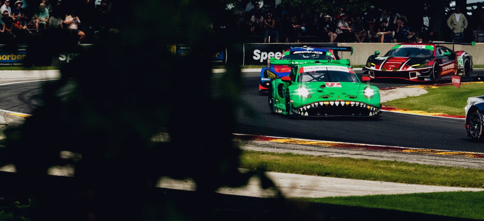 AO Racing's "Rexy" car in motion at the IMSA Sports Car Weekend 2025 on an outdoor circuit.