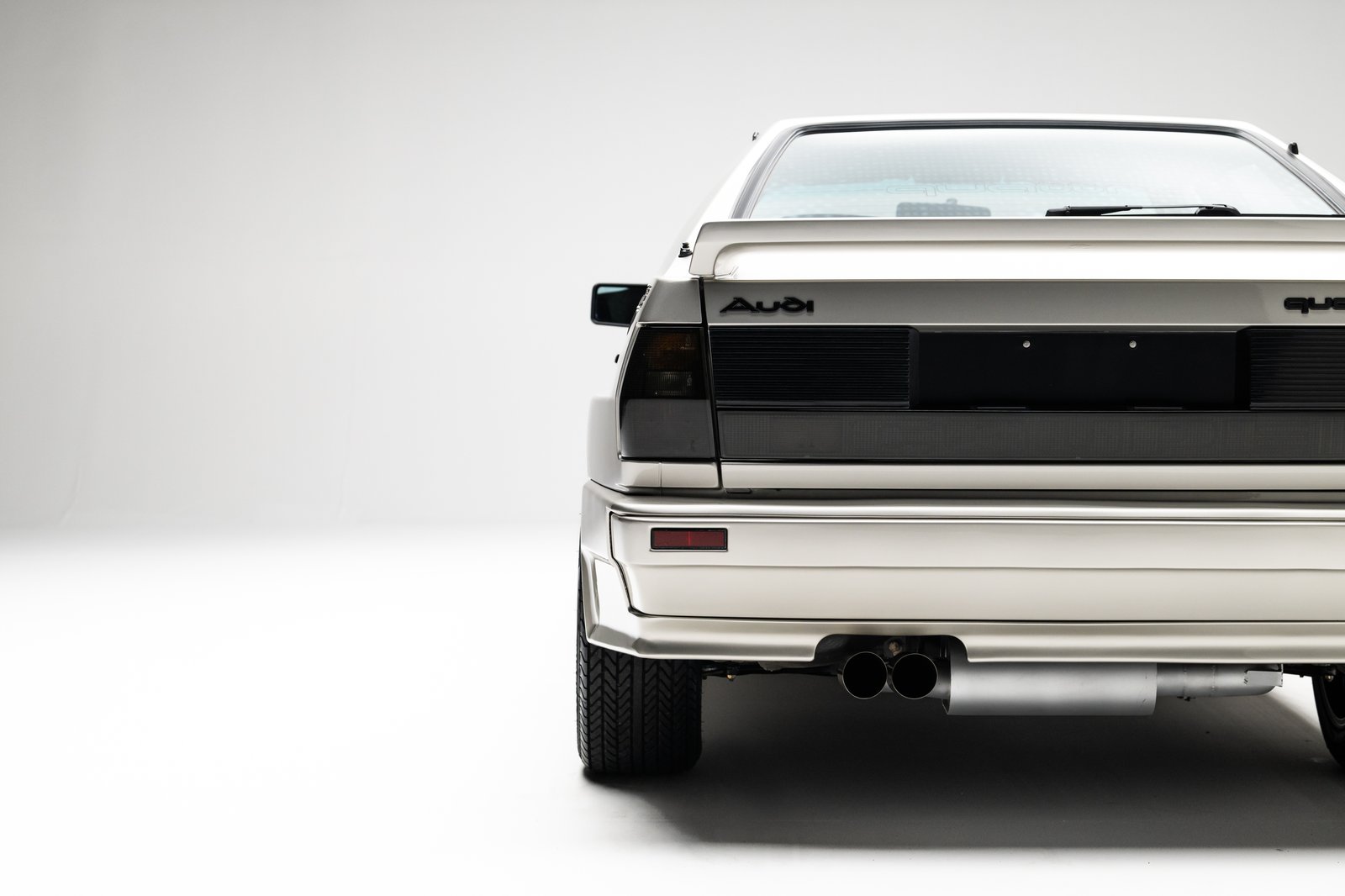 Rear studio view of the 1986 Audi WR Ur-Quattro showing the black rear panel and dual exhaust.