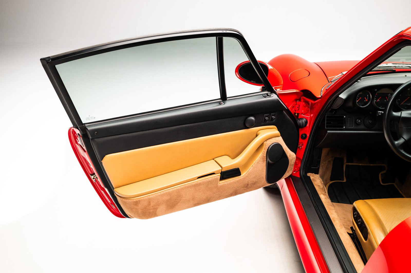 The image shows the interior of a 1998 Porsche 911 Carrera S coupe with the driver's side door open. Notable features include a Cashmere beige leather door panel and a view of the dashboard and steering wheel.