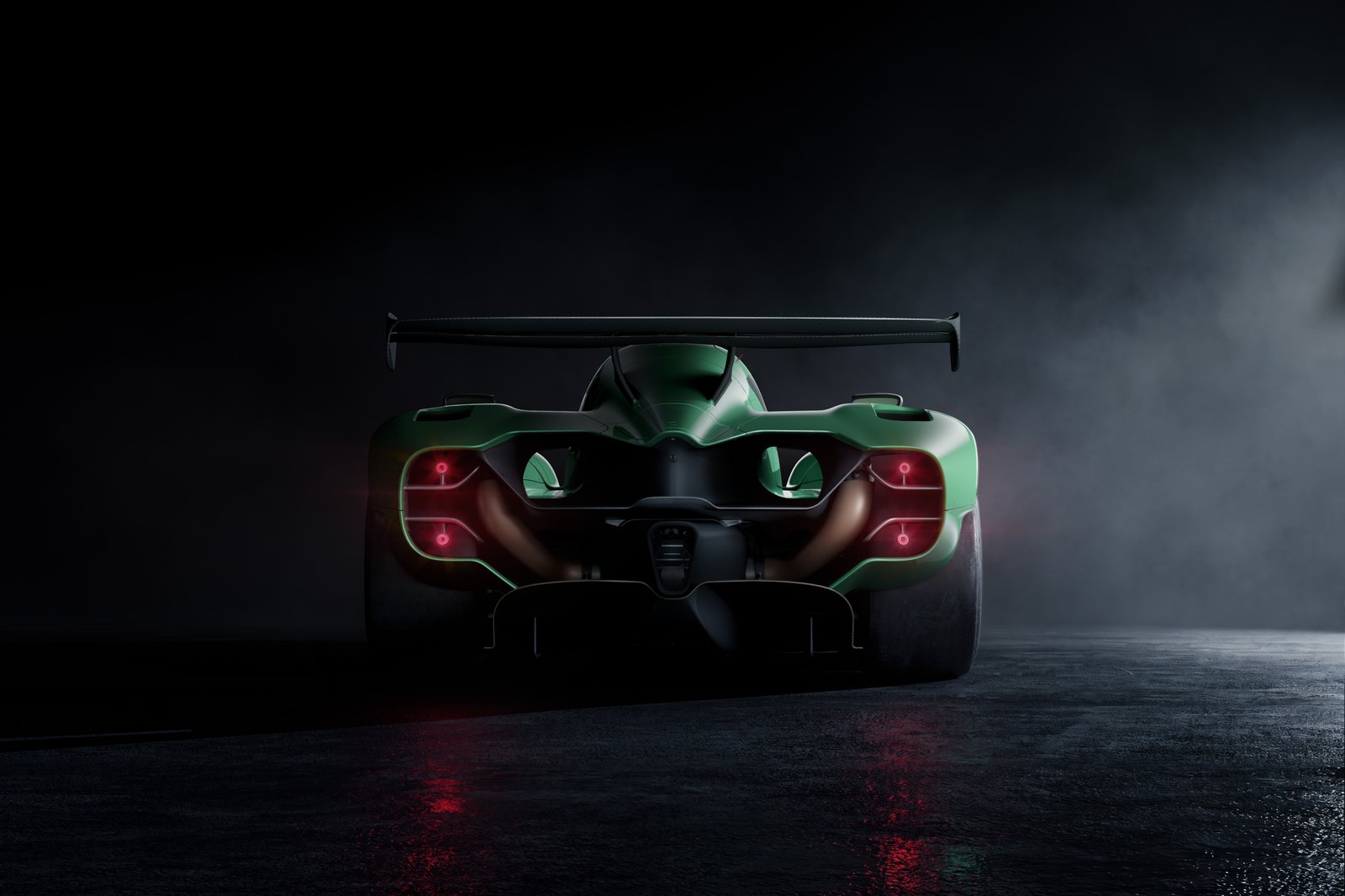 A green race car is shown from the rear in a dark studio with mist and a wet reflective floor. The rear taillights glow red, and a large rear wing spans the top of the vehicle.