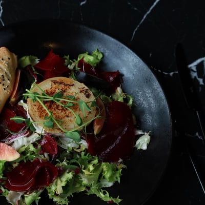 Sałatka z grillowanym kozim serem, figą i burakiem, świeża przystawka restauracyjna z winegretem i włoskim pieczywem