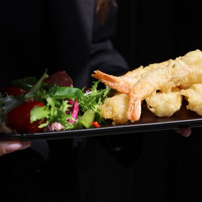 Krewetki w tempurze 6 sztuk z mixem sałat i dipem, chrupiąca przystawka w restauracji, świeże owoce morza podane na elegancko