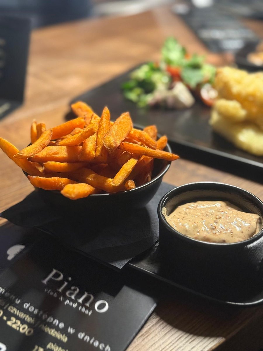 Frytki z batata z kremowym sosem podane w eleganckiej restauracji, apetyczna przystawka w lokalu Piano idealna na lunch i kolację