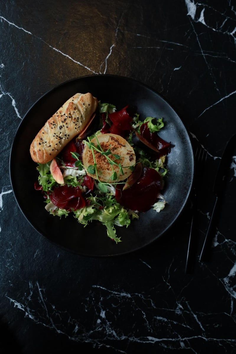 Sałatka z grillowanym kozim serem, figą i burakiem z winegretem oraz włoskim pieczywem – eleganckie danie w restauracji