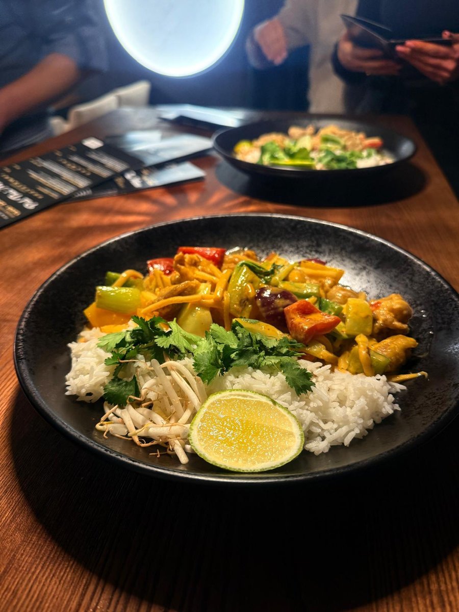 Gaeng Phed, czerwone curry z pędami bambusa, papryką i mlekiem kokosowym, podane z ryżem w tajskiej restauracji, aromatyczne danie