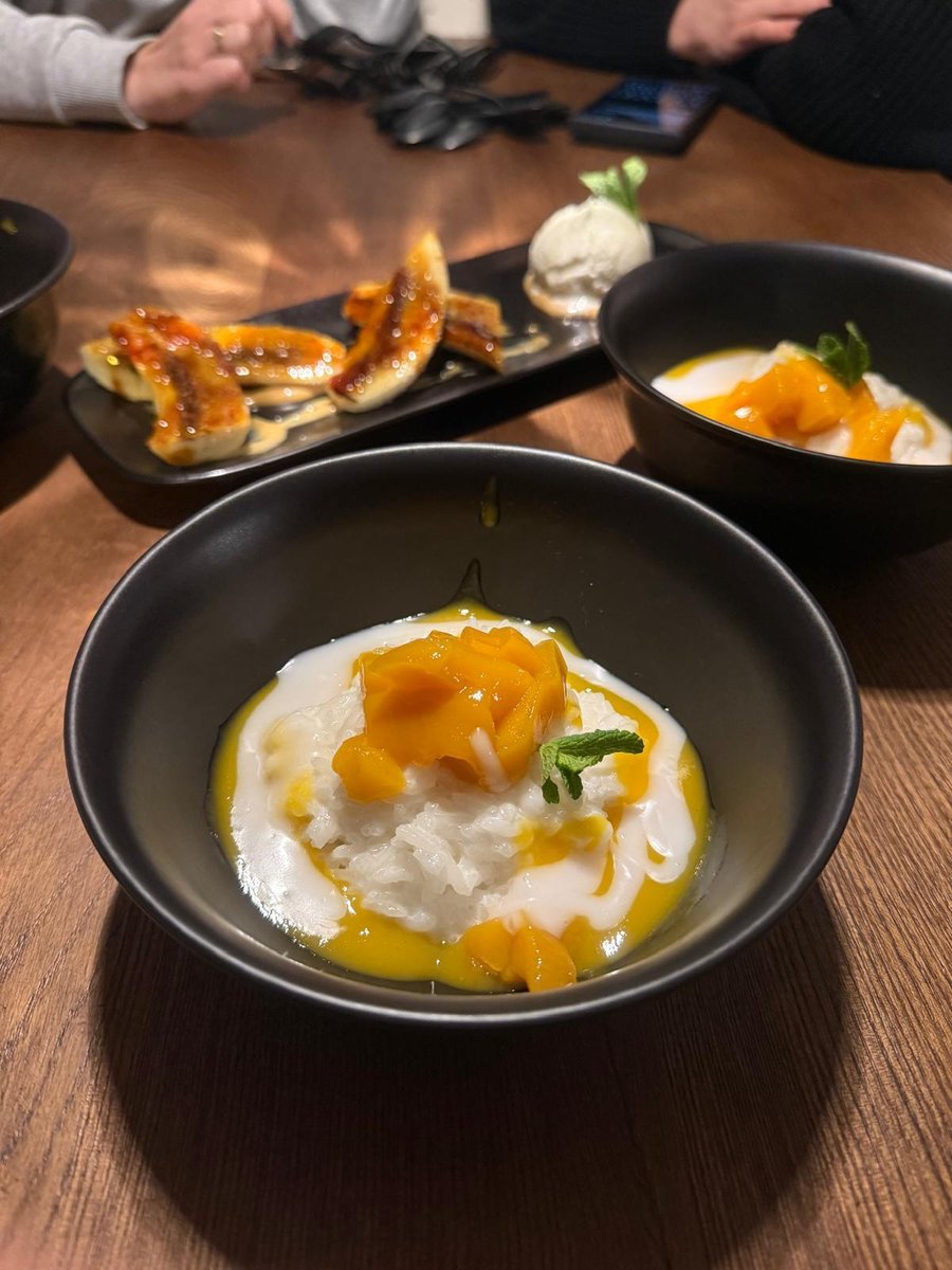 Mango Sticky Rice z kremem kokosowym i świeżym mango podane w restauracji azjatyckiej – deser tajski na elegancko nakrytym stole