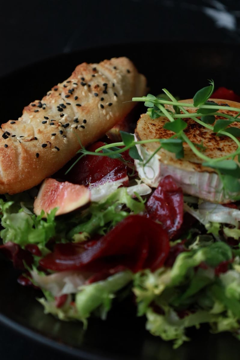 Sałatka z grillowanym kozim serem, figą i burakiem z winegretem oraz włoskim pieczywem – świeże danie w restauracji