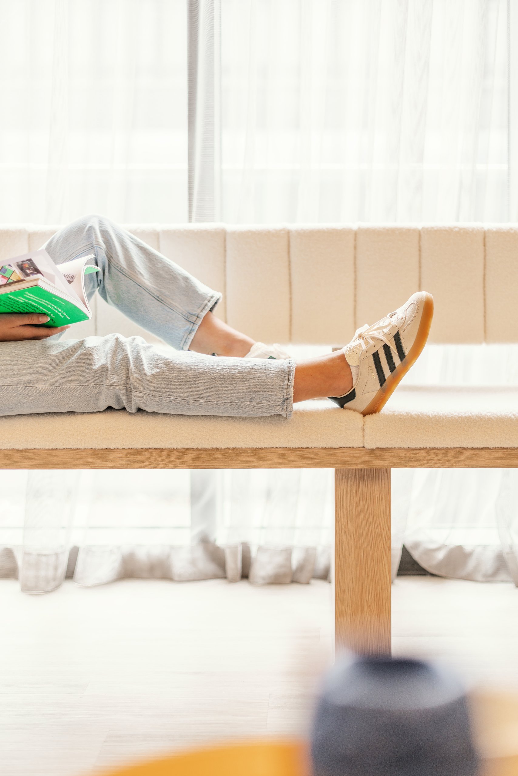 person reading book sat on sofa