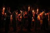 White nationalists carrying tiki torches walk through the University of Virginia campus at night.