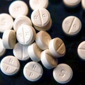 Twenty-two 5-mg pills of the opioid Oxycodone on a table.