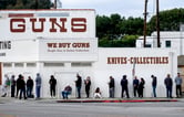 A line of people waiting to enter a gun store.