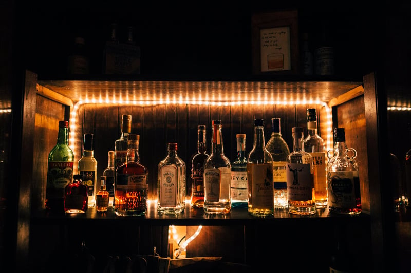 Bottles of whiskey, rum and other liquors on a shelf.