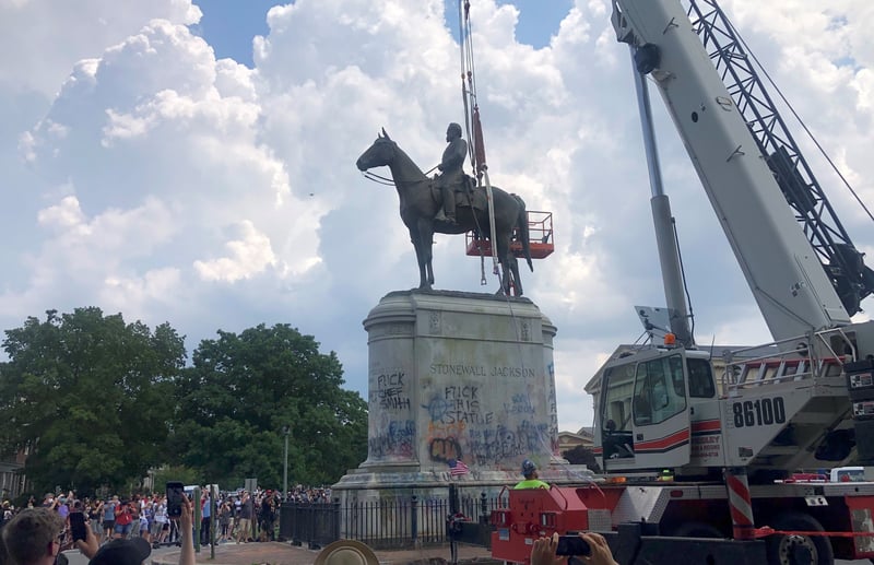 A crane prepares to remove a statue of Stonewall Jackson.