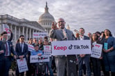 Jamaal Bowman gestures while giving a speech in front of the U.S. Capitol, with several people standing around him holding signs supporting TikTok.