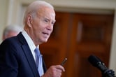 close-up of President Joe Biden speaking, wearing a dark suit and light blue tie