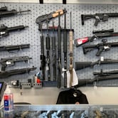 A variety of guns, including shotguns and rifles, on display at a gun shop.
