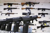 Assault weapons and hand guns displayed on a wall and counter