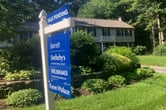 A Barrett Sotheby's International Realty sign noting a pending sale outside a two-story house.