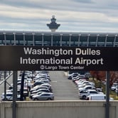 A sign for Dulles International Airport outside a parking lot.