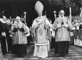 A black and white photo of members of the Catholic Church walking with Pope Pius XII during a ceremony.