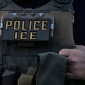 Close-up of a tactical vest labeled "POLICE ICE" worn by a law enforcement officer.