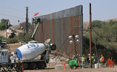 Several workers work on constructing more sections of a boarder wall on the U.S.-Mexico border.
