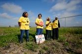 Four women conduct a protest on a field in Louisiana.