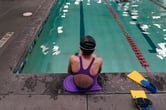 A transgender girl swimmer sits next to a pool in Utah.