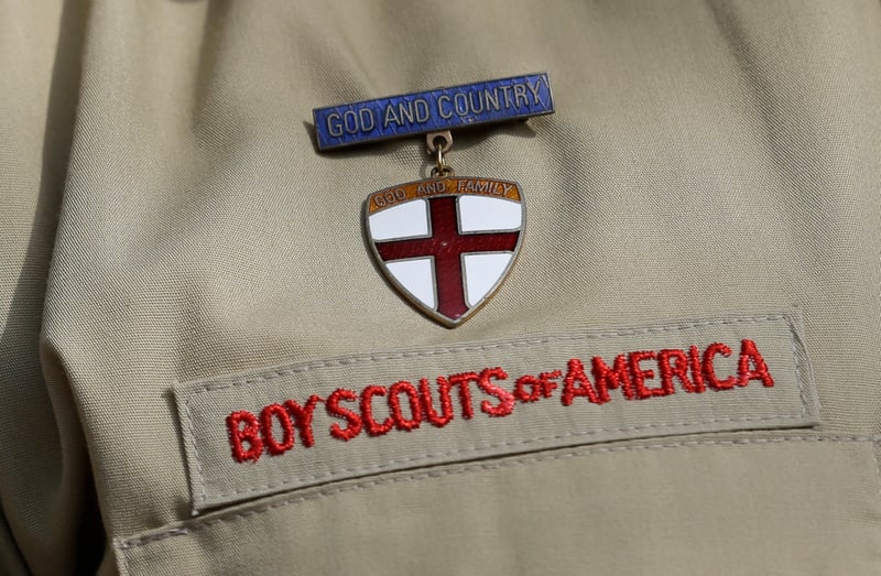 A pin and a patch on a Boy Scouts uniform.
