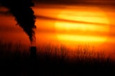 Smoke rises from a coal-fired power plant as the sun begins to set.