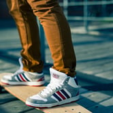 The legs and feet of someone riding a skateboard.