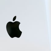 The Apple logo is displayed on a Mac Pro desktop computer