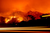 This photo shows an entire hillside on fire.