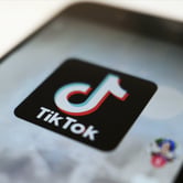 The TikTok app icon is seen on a smartphone screen.