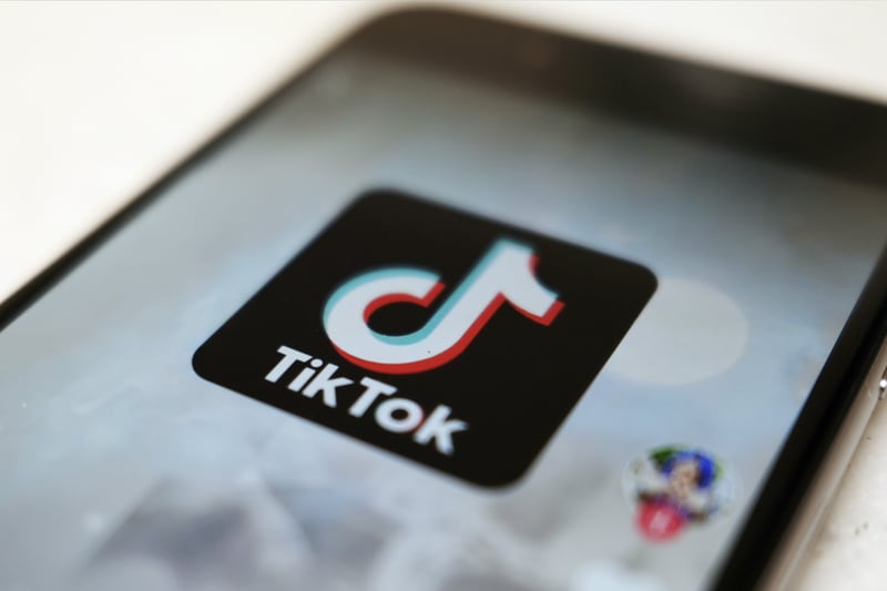 The TikTok app icon is seen on a smartphone screen.