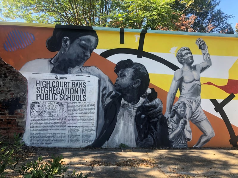 Mural depicting a mother and child with a newspaper, the headline says: "High Court Bans Segregation in Public Schools"