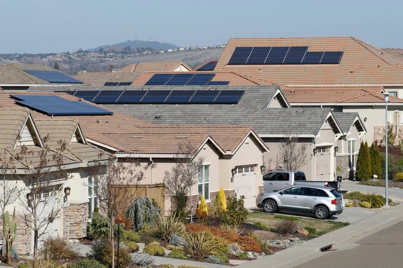 Solar panels on the rooftops of several houses.