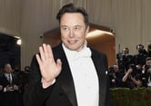 Elon Musk waves as he arrives at the Met Gala.