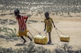 Young girls pull containers of water during a drought in Kenya.