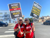 Two workers with strike signs outdoors