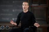 Mark Zuckerberg sits while speaking on stage.
