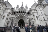 Media members stand outside the High Court in London.