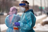 A nurse wearing personal protective equipment prepares a Covid-19 test outside in Salt Lake City.