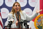 Ronna McDaniel gestures while speaking on stage at an event in Florida.